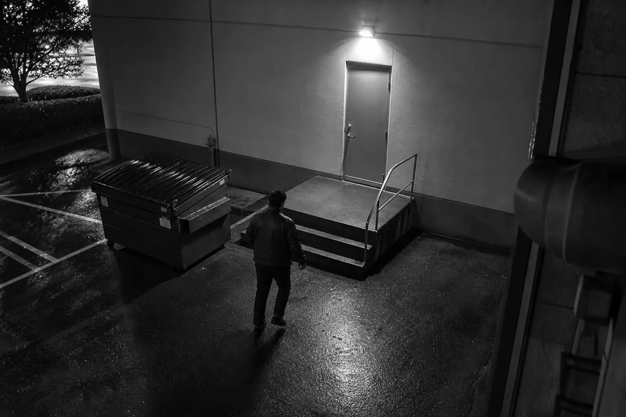 Security camera watching the rear service entrance of a retail building at night